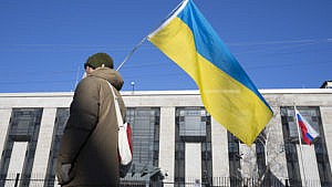 A pro-Ukrainian supporter waves the country's flag outside the Russian embassy on Feb. 24, 2022 in Ottawa (Adrian Wyld/CP)
